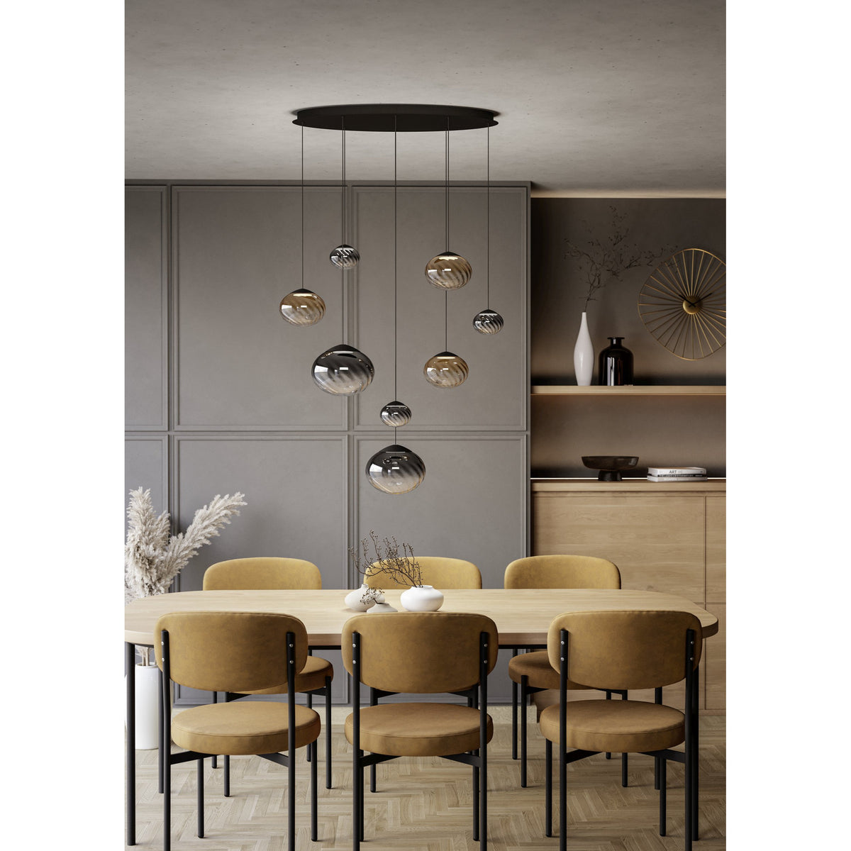 Pantoja Amber Glass 8 Light Pendant in Black, with ribbed globes in amber and smoke tones cascading from an oval canopy above a dining table.