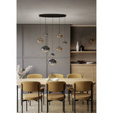 Pantoja Amber Glass 8 Light Pendant in Black, with ribbed globes in amber and smoke tones cascading from an oval canopy above a dining table.
