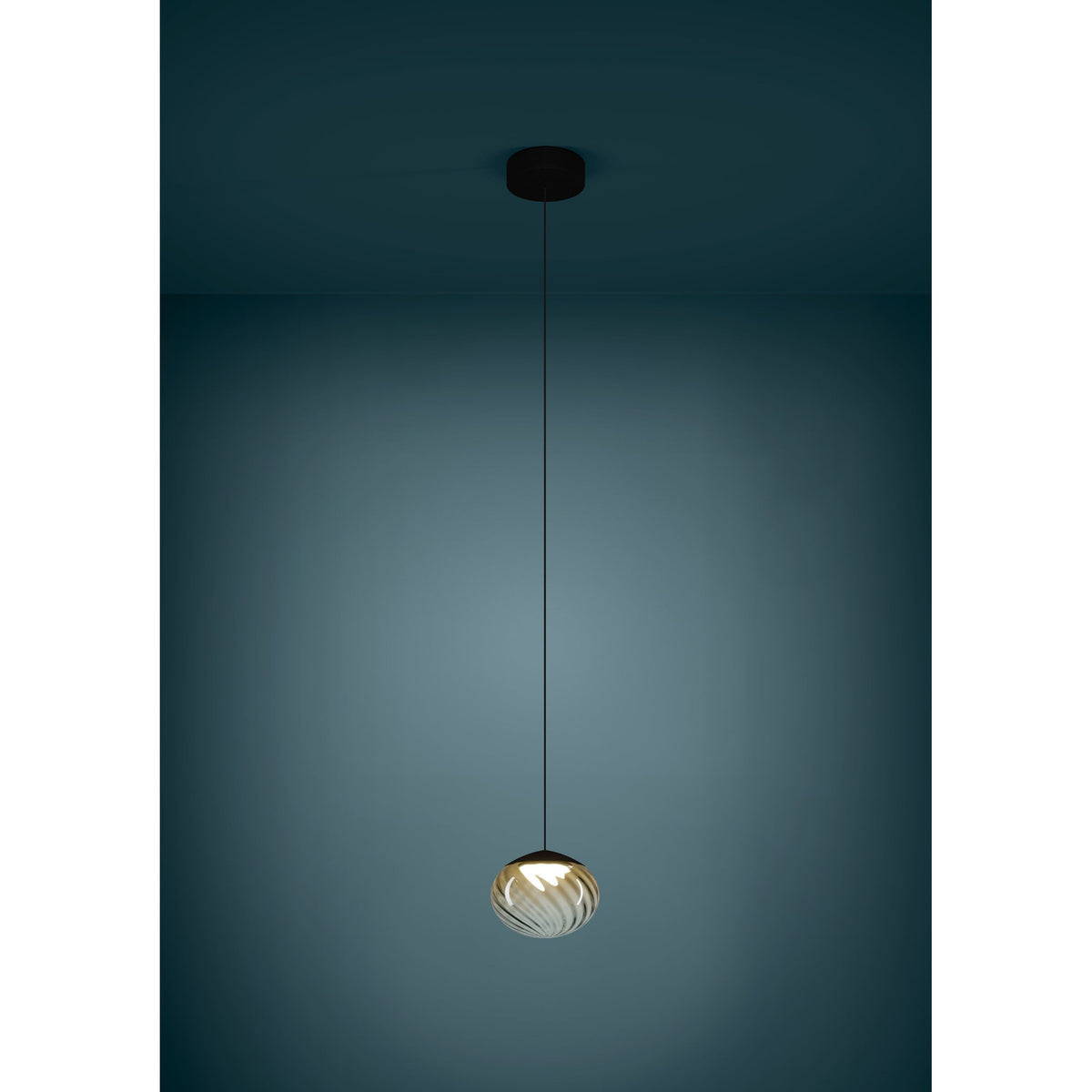 Pantoja pendant light with a round ribbed amber glass globe, black ceiling canopy and black cord, shown illuminated against a dark teal background.