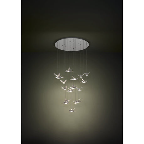 Paratebueno 17 light pendant in chrome, bird-shaped LED shades suspended at staggered heights from a round steel ceiling canopy, warm white glow against a dark background.