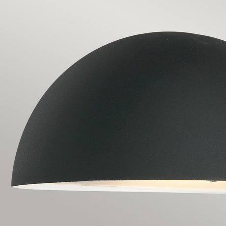 A close-up of the Paris Outdoor Small 1 Light Wall Lantern in a sleek matte black finish against a light gray background. Its lower edge emits a soft glow, making it a perfect addition to any outdoor lighting scheme with modern hanging light features.