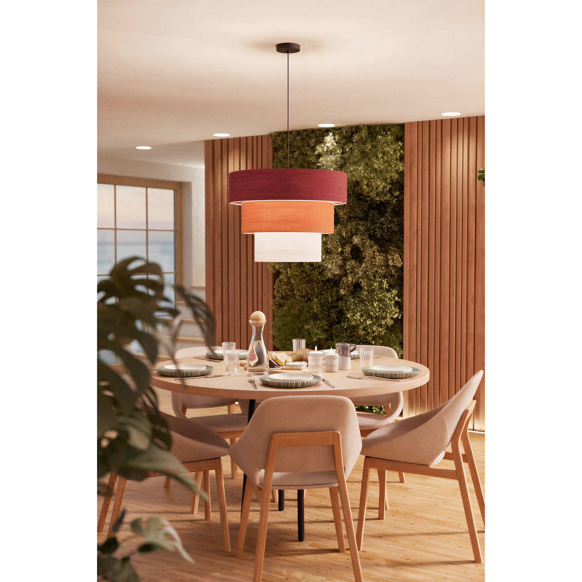Parogno Fabric Pendant Light with three stacked drum shades in red, orange and white on a black cable and canopy, shown above a round dining table.