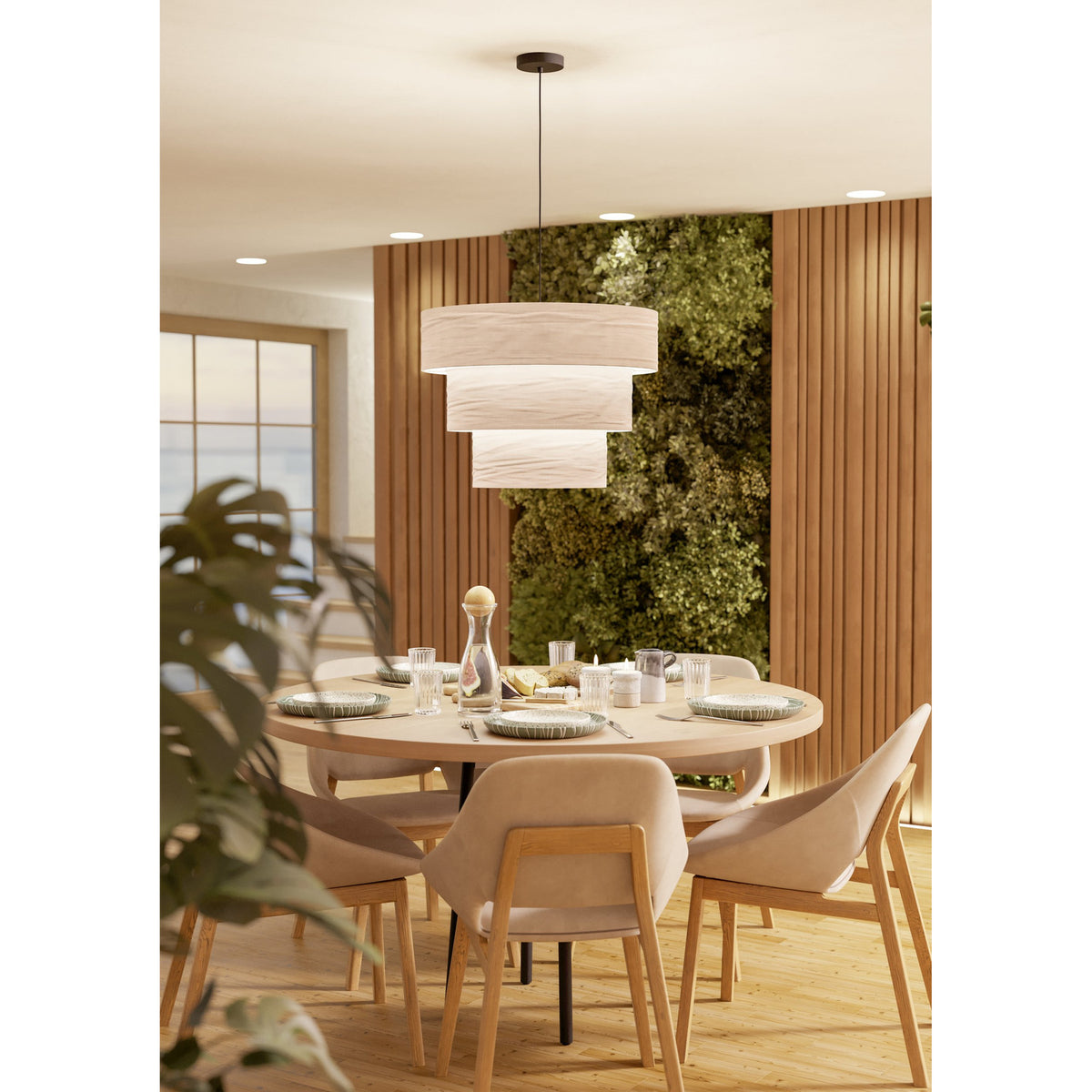 Parogno Fabric Pendant Light in black and white, three-tier cream fabric drum shades on a black steel canopy and cord, hung above a round dining table.