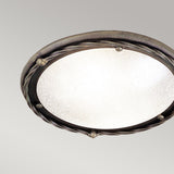 The Pembroke 1 Light Flush Light in black/gold is a round, ornate fixture with a frosted glass cover and a decorative hand-forged iron rim adorned with a twisted pattern and small metal accents. It is set against a plain light gray background.