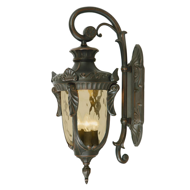 The Philadelphia 3 Light Outdoor Large Down Wall Light in Old Bronze showcases vintage-style charm with its ornate metal detailing and curved arm. With amber glass panels, it is designed to accommodate a candle or light bulb.