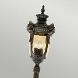 The Philadelphia 3 Light Large Lamp Post in Old Bronze features a vintage-style outdoor lantern with ornate detailing and a clear glass casing that showcases lit bulbs inside. This lamp post adds timeless charm to your outdoor lighting decor.