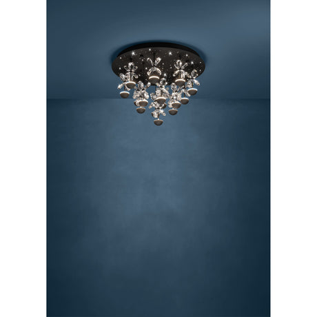 Pianopoli 2 15 Light Ceiling Light in black, featuring a round steel canopy with cascading clear glass flower details and integrated LED stems, shown mounted against a dark blue wall and ceiling.