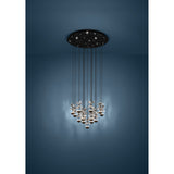 Pianopoli 2 cluster pendant light with black perforated round ceiling canopy and fifteen staggered drops of clear faceted glass petals over black LED domes, shown against a dark blue wall.