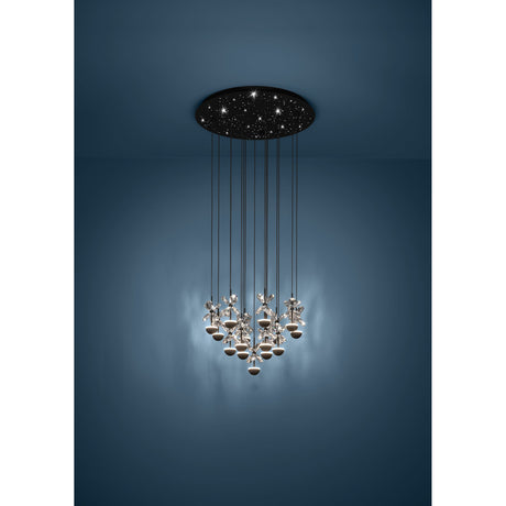 Pianopoli 2 cluster pendant light with black perforated round ceiling canopy and fifteen staggered drops of clear faceted glass petals over black LED domes, shown against a dark blue wall.
