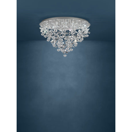 Pianopoli 43 Light Ceiling Light in chrome, a round flush fitting with cascading clear glass flowers and chrome drops tapering to a point, shown against a dark blue background.