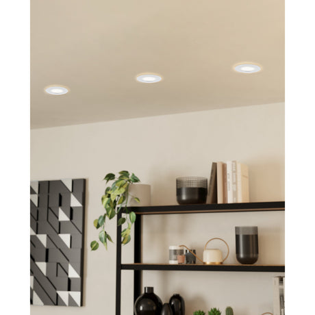 Pineda Fixed LED Downlight Set of 3 in white shown recessed into a ceiling above a shelving unit with books and decor, round plastic fittings with frosted diffusers.
