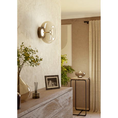 Pismarne LED Ceiling Light in bronze with a smoked glass bubble shade, shown mounted on a textured wall in a living room setting.