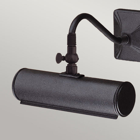 The Picture Light 1 Light Small - Black is a wall-mounted fixture designed to illuminate artwork, featuring a cylindrical shade and an adjustable arm. It includes a decorative fitting at the joint and boasts a sleek black finish with a square base for a modern appearance.
