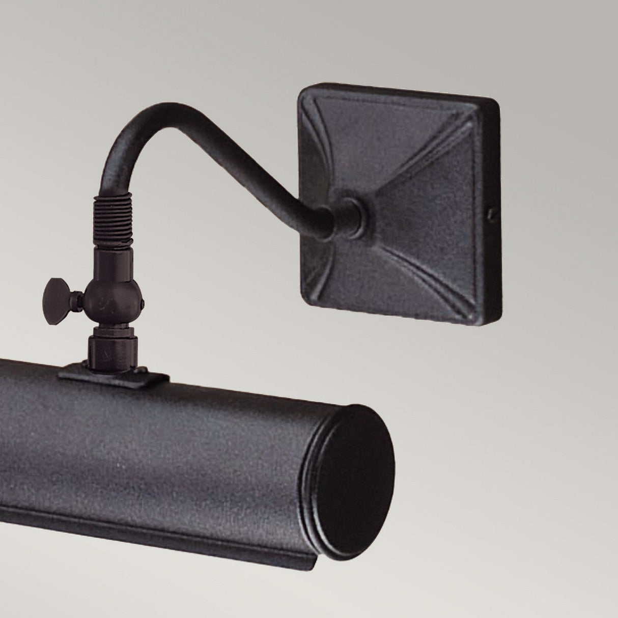 The Picture Light 1 Light Small - Black is a wall-mounted metal light fixture in an industrial design, featuring an adjustable arm and a black finish. It has a cylindrical shape with a square back plate, set against a neutral background.