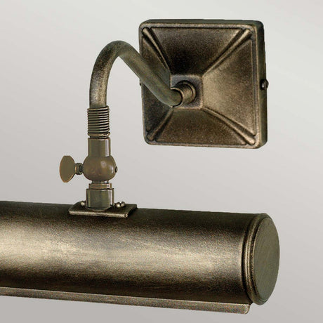 Introducing the Picture Light 1 Light Small - Black/Gold: a wall-mounted light fixture designed in a vintage industrial style, ideal for illuminating artwork. It showcases a rectangular backplate, curved arm with a decorative valve, and cylindrical light housing, all elegantly finished in weathered bronze with subtle black and gold accents.
