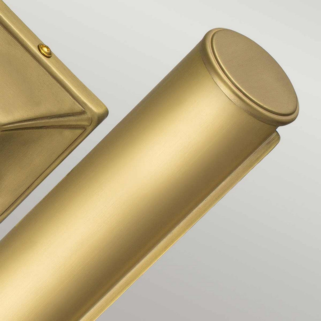 The Picture Light 2 Light Large in brushed brass offers a sleek, cylindrical design with a modern touch. Its minimalist elegance is complemented by a soft metallic shine, making it an ideal choice for illuminating artwork. The fixture is mounted on a rectangular brass plate, adding an extra layer of sophistication to its overall appearance.