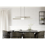 Playitas Pendant Light in satin nickel, two slim parallel steel bars with integrated LED, hung on fine wires above a black dining table in a neutral-toned dining room.