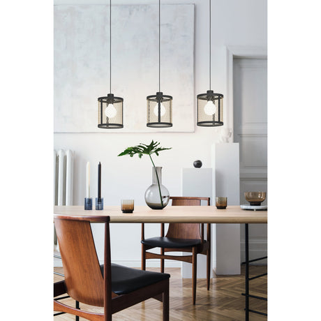 Polbena Linear Pendant Light in black steel with three cylindrical cage shades and brass-toned mesh, hung at varying heights above a dining table in a living room setting.