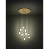 Portocolom Glass 10 Light Pendant in Brass & Gold, round ceiling plate with ten staggered black cords, gold rings holding opal glass globes, shown lit against a dark background.