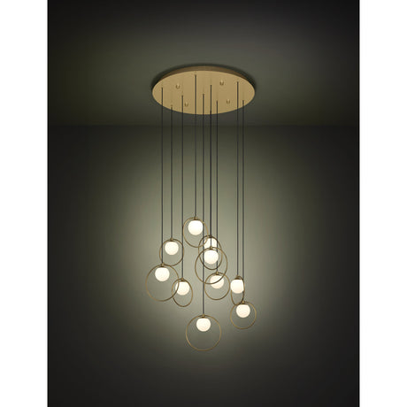Portocolom Glass 10 Light Pendant in Brass & Gold, round ceiling plate with ten staggered black cords, gold rings holding opal glass globes, shown lit against a dark background.