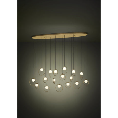 Portocolom 17-light linear pendant with opal glass globes in gold rings on black cords, suspended from a long oval brass and gold ceiling canopy against a dark background.