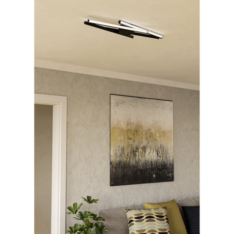 Pradilla LED Flush Ceiling Light in black, with crossed aluminium bars and white diffusers, mounted on a living room ceiling above a framed abstract artwork.