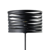 Pranvorne floor lamp in black steel, featuring a drum shade made from overlapping woven bands on a slim stem, shown close-up with visible E27 bulb against a white background.