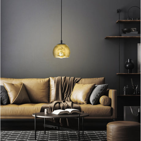 Prelvelle Glass Pendant Light 19cm in Black, a single gold-toned globe shade on a black cord and ceiling canopy, shown above a tan sofa in a dark living room setting.