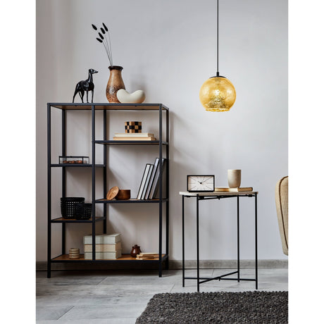 Prelvelle Glass Pendant Light 27cm in gold-flecked glass with black steel canopy and cable, shown hanging above a side table in a living room with a dark shelving unit.