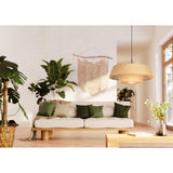 Prenvanne Pendant Light in black with a two-tier woven bast shade in natural straw tone, hung above a living room sofa and coffee table on a black cable and stem.