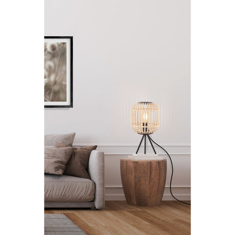 Prolbane Table Lamp in black with a rounded natural wood slat shade on a black steel tripod base, shown on a wooden side table beside a sofa.