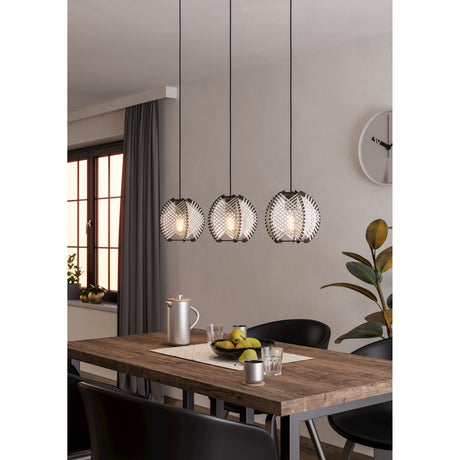 Prosena Wooden Linear Pendant Light with three criss-cross woven black and white globe shades on black cords, shown above a wooden dining table in a neutral-toned room.