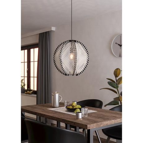 Prosena Wooden Pendant Light 48cm in black, wood and white, round woven shade with crossing black and white strips, hung over a dining table in a living space.