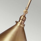 Close-up of the Provence 1 Light Wall Light/Pendant in aged brass, showcasing its smooth conical shade and adjustable rod. The polished metal finish gleams with a vintage charm against a neutral gray background.