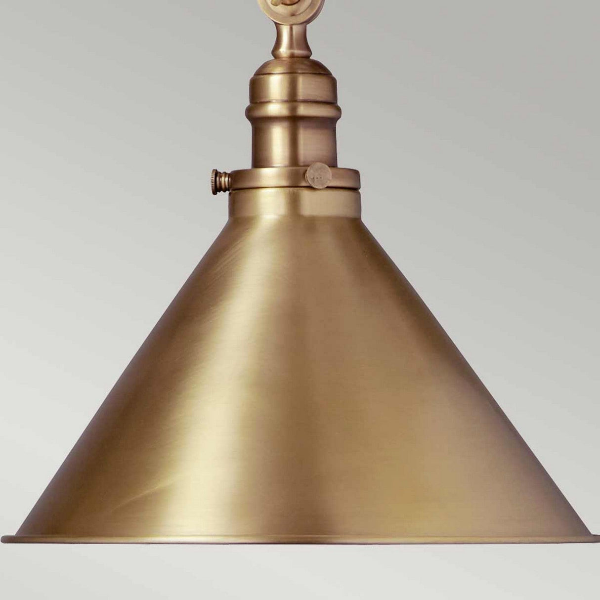 The Provence 1 Light Wall Light/Pendant in aged brass features a conical shade hanging against a plain background, showcasing its brushed metallic surface that exudes vintage flair and an elegant, classic appearance.