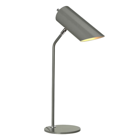 The Quinto 1 Light Table Lamp in Dark Grey and Polished Nickel, featuring a cylindrical shade and an adjustable head on a circular base, effortlessly complements industrial-style interiors. When turned on, it emits a warm glow.