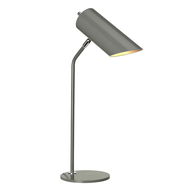 The Quinto 1 Light Table Lamp in Dark Grey and Polished Nickel, featuring a cylindrical shade and an adjustable head on a circular base, effortlessly complements industrial-style interiors. When turned on, it emits a warm glow.