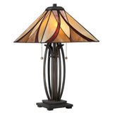 The Asheville 2 Light Tiffany Table Lamp - Valiant Bronze features a stained glass shade in a classic Tiffany-style with an abstract pattern of beige, amber, and red. The lamp is supported by an iron frame, operates with two pull chains, and sits on a dark, sturdy rectangular base finished in valiant bronze.