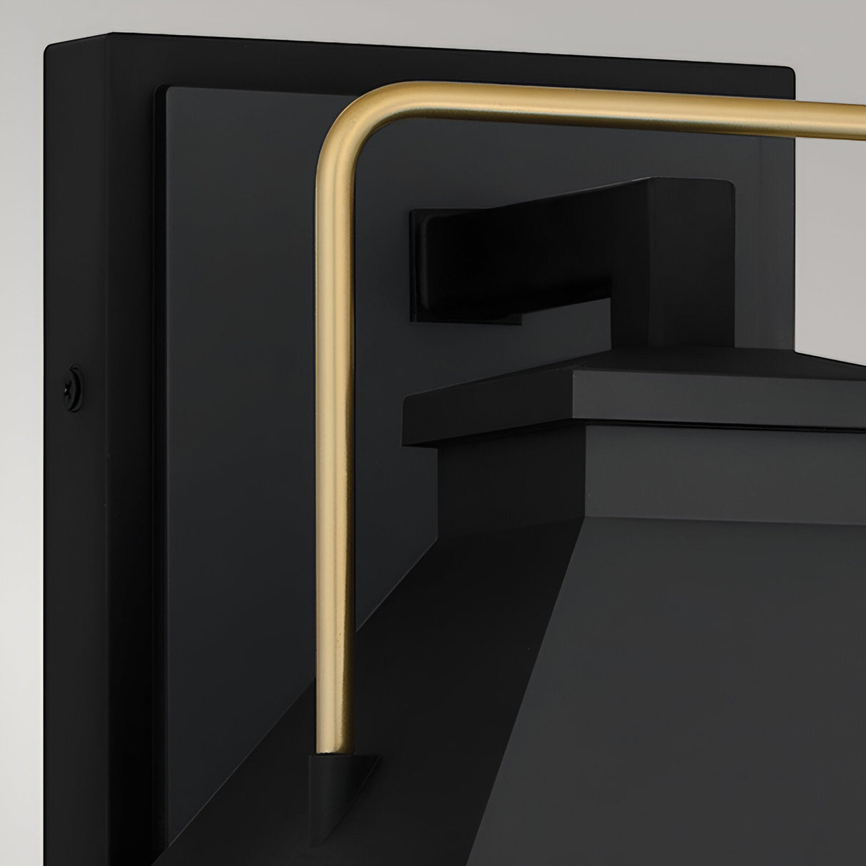 Close-up of the Buckley 1 Light Coastal Medium Outdoor Wall Lights Lantern in black, showcasing its modern matte finish, rectangular backplate, angled top, and a gold cylindrical metal arm.