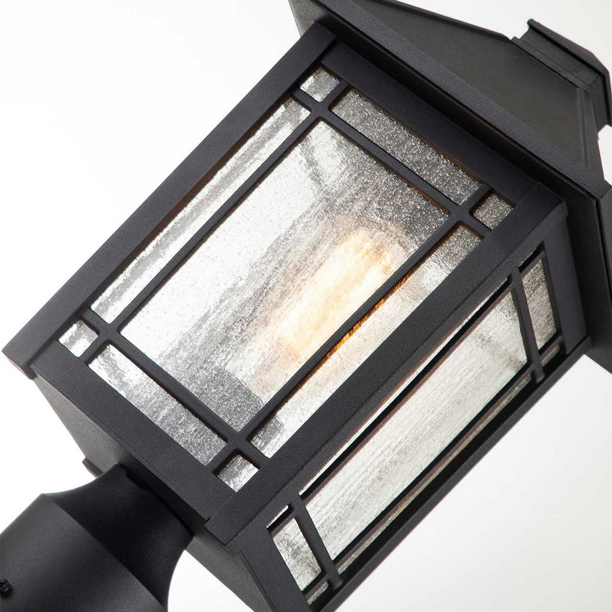 The Cedar Point 1 Light Pedestal - Black exudes vintage character with its lit bulb and simple geometric design. Its glass panels and metal framing create a warm glow, making it perfect for stylishly illuminating outdoor pathways.