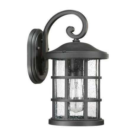 Introducing the Crusade Outdoor 1 Light Medium Wall Lantern in black, featuring an elegant scroll design at the top. This IP44-rated fixture is crafted to withstand the elements and displays clear, textured glass panels that accentuate a visible light bulb inside. Supported by a sturdy metal frame, it exudes a charming rustic appearance ideal for any setting.