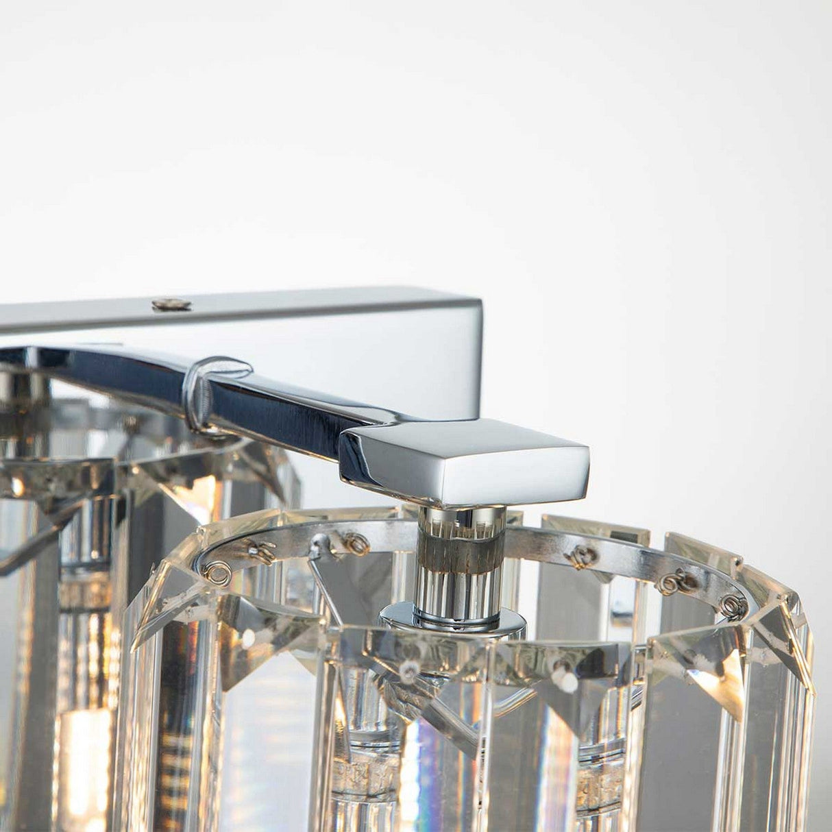 Close-up of the Divine 1 Light Wall Light in polished chrome, showcasing prismatic crystal glass panels for a sleek and elegant design.
