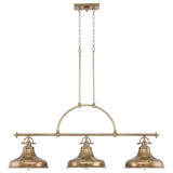 The Emery 3 Light Island Pendant in Weathered Brass, boasting an industrial-style design with three round lampshades, hangs gracefully from the ceiling. Supported by a metal rod and chain, this fixture exudes elegant charm through its vintage-inspired aesthetic.