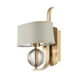 The Gotham 1 Light Wall Light - Brushed Brass is a contemporary wall sconce that elevates any interior with its sleek design. It includes a cylindrical white shade and a glass orb, merging elegant metal lines with a curved backing for an exquisite addition to modern spaces.