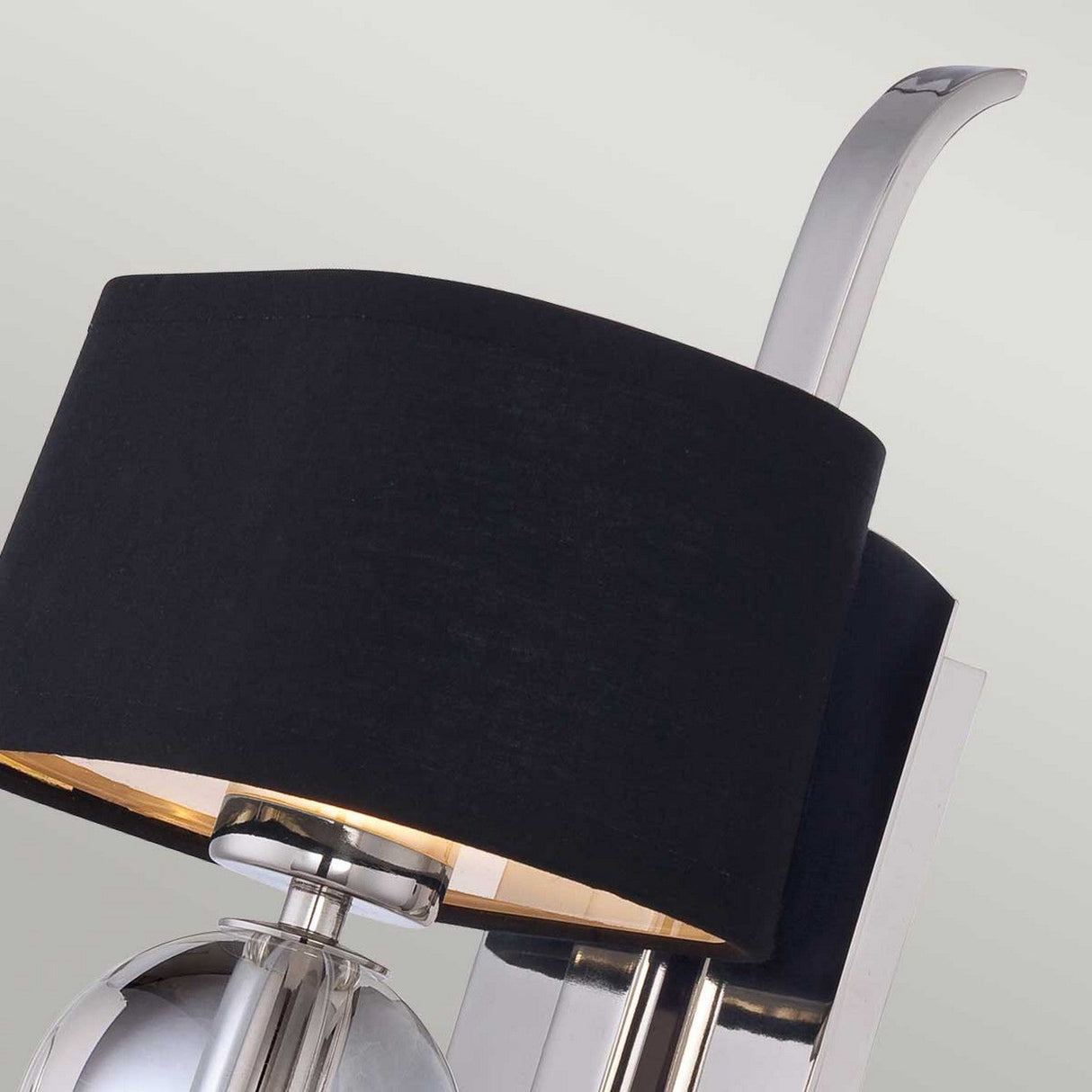 Introducing the Gotham 1 Light Wall Light, crafted in elegant Imperial Silver. This modern fixture features a sleek metal base and a black cylindrical shade with a distinctive curved handle-like extension at the top, radiating contemporary charm. It's an ideal addition to any modern decor and is set against a light, neutral background.