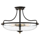 A Griffin 3 Light Large Semi-Flush ceiling fixture with a Palladian Bronze finish and weathered brass accent, featuring clear glass shades. The design includes elegant curved arms connecting to a round ceiling mount and accommodates three Edison-style bulbs.