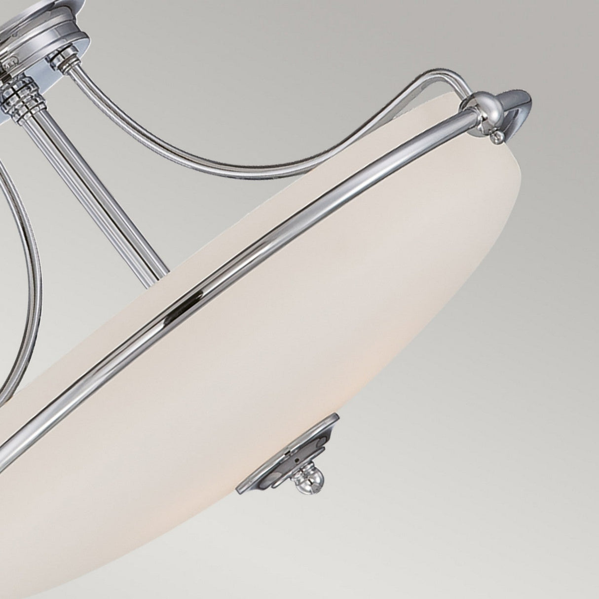 A close-up of the Griffin 4 Light Semi-Flush in polished chrome showcases its modern elegance, featuring a frosted white glass dome with sleek metal accents. Set against a light gray background, this sophisticated design enhances any space.