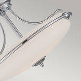 A close-up of the Griffin 4 Light Semi-Flush in polished chrome showcases its modern elegance, featuring a frosted white glass dome with sleek metal accents. Set against a light gray background, this sophisticated design enhances any space.
