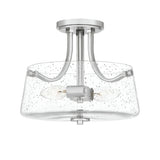 The Hollister 2 Light Semi-Flush - Polished Nickel ceiling fixture showcases a polished nickel finish and a clear seeded glass shade. It includes two exposed bulb sockets joined by gracefully curved metal arms, offering a modern and chic look.