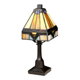 The Holmes 1 Light Mini Tiffany Table Lamp in vintage bronze boasts a geometric stained glass design with shades of amber, purple, and white. It features an ornate dark base and a pyramid-shaped shade that captures the Art Deco style of a classic Tiffany lamp.